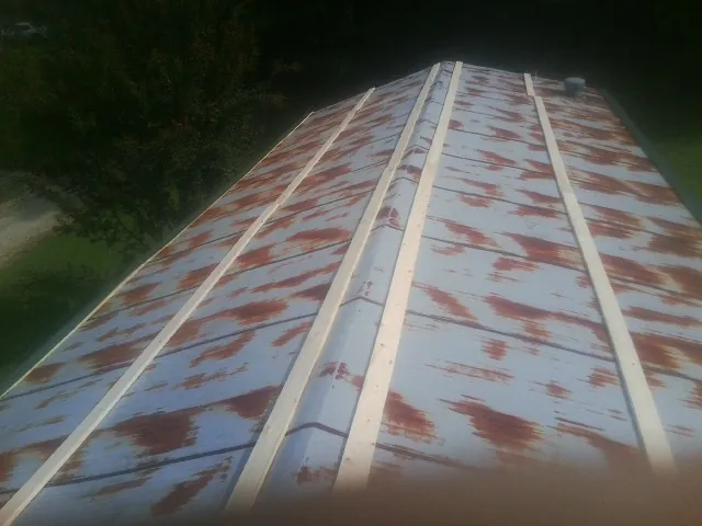 Rusted metal roof panels with new wood purlins before replacement — Storm Damage Roof Repair in Douglass by Roofing Brothers