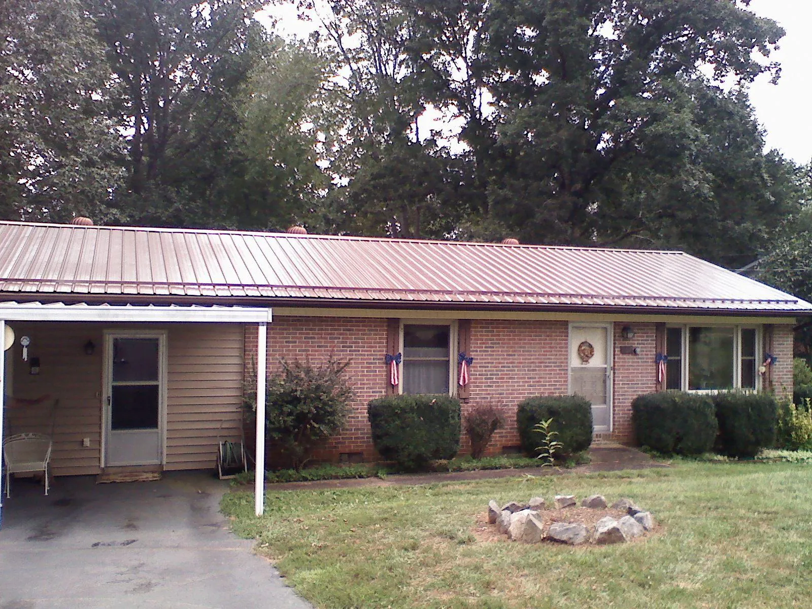 Bronze metal roof and carport on a brick ranch home — Roof Repair work by our crew in Douglass